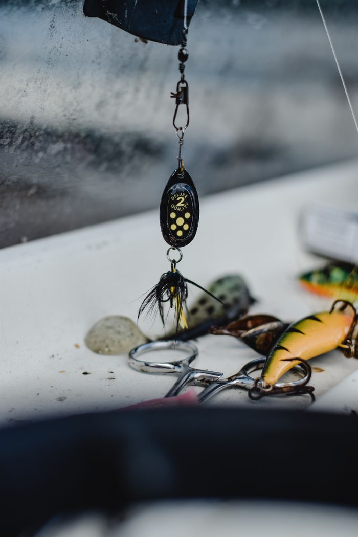 The Art of Drawing Readers In: Your attractive post title goes here Detailed shot of fishing accessories including lure and scissors in a vibrant arrangement.
